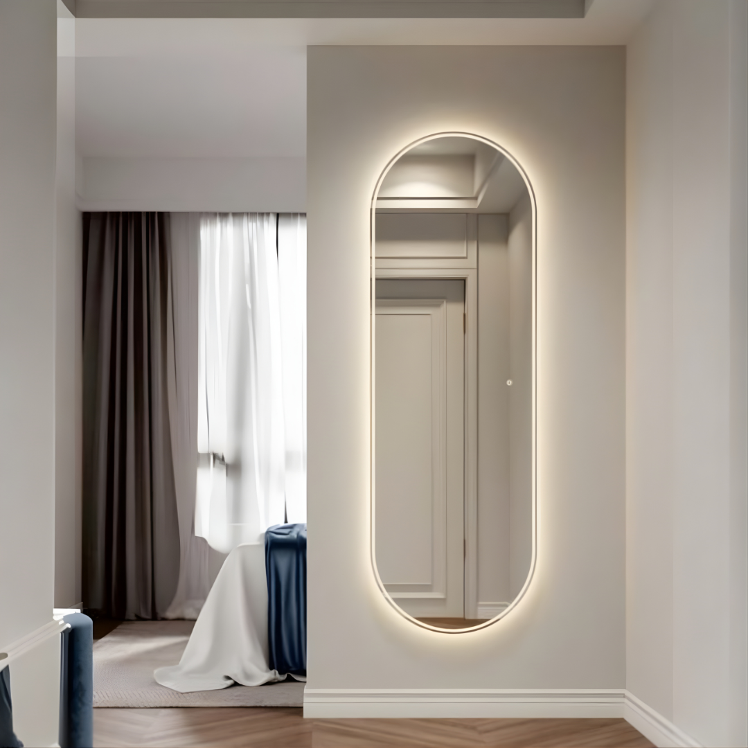 Modern interior with a large oval mirror on a wall, reflecting a room with curtains.