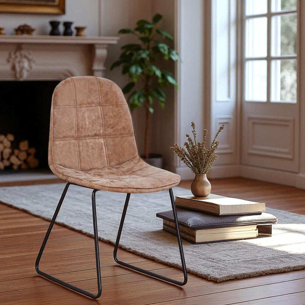 Brown upholstered chair in a room with a fireplace and books on a rug