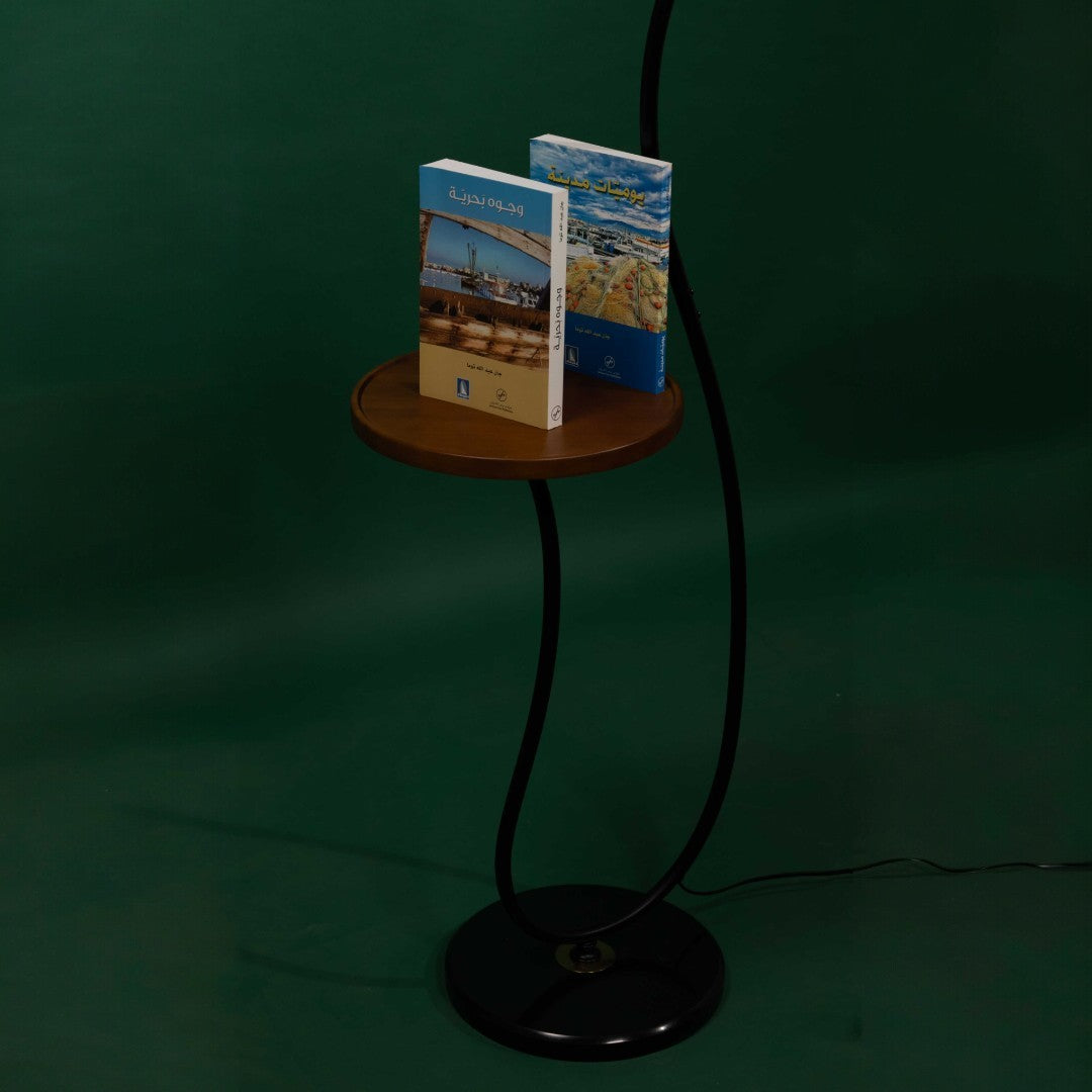 small wooden shelf holding books for a black floor lamp
