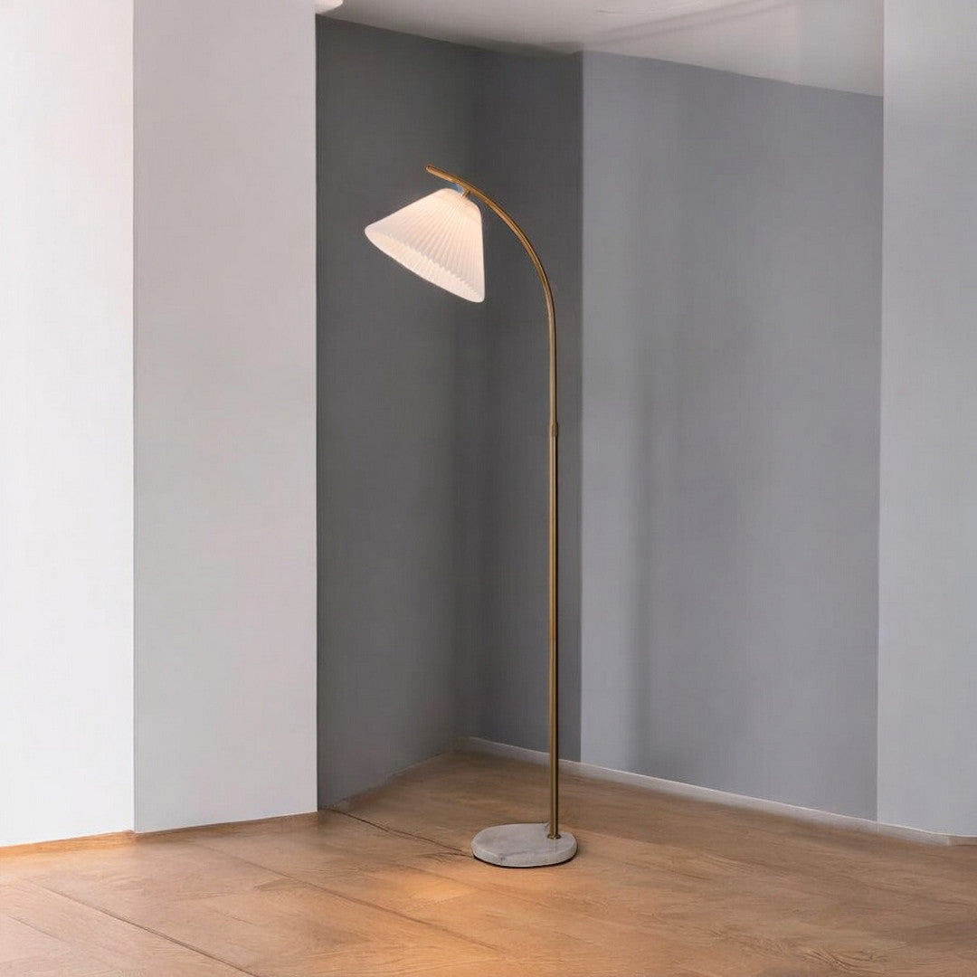 A simple arched floor lamp with a white lampshade, standing in a contemporary interior space.