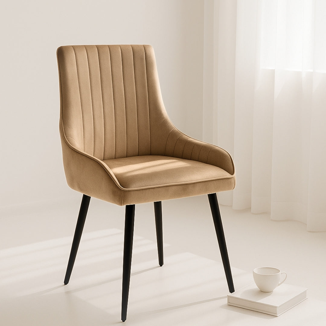 Beige upholstered chair with black legs in a minimalistic room.