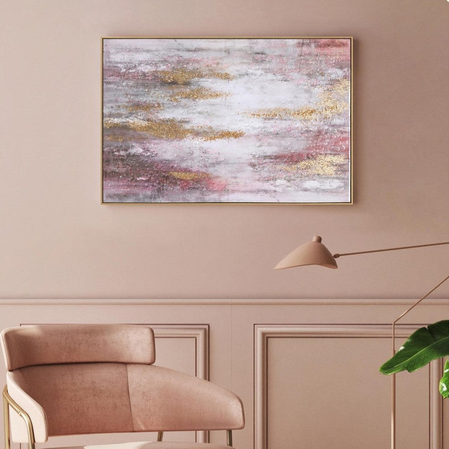 Modern living room with a pink chair, ottoman, and abstract painting on a beige wall.