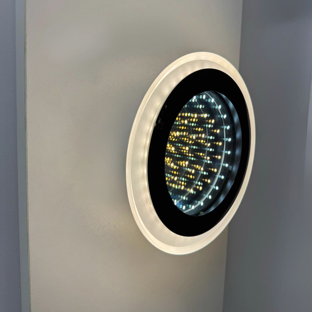 Modern circular LED wall light with a futuristic infinity mirror effect, emitting warm and cool light patterns inside a glossy black and white frame.
