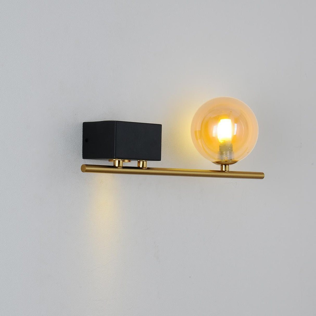 A sleek gold bar with a cylindrical black box on one side, housing an LED light, and an exposed bulb on the other