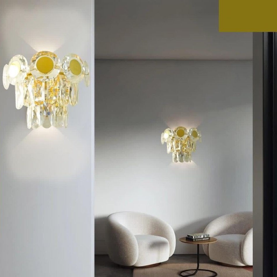 A elegant wall-mounted light with a combination of gold and crystal elements.