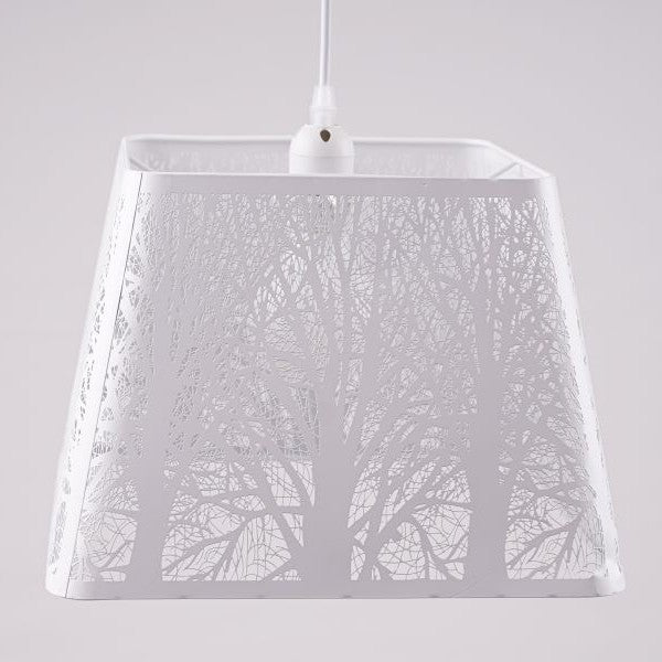 A white square-shaped pendant lampshade with intricate tree patterns cut into the metal frame.