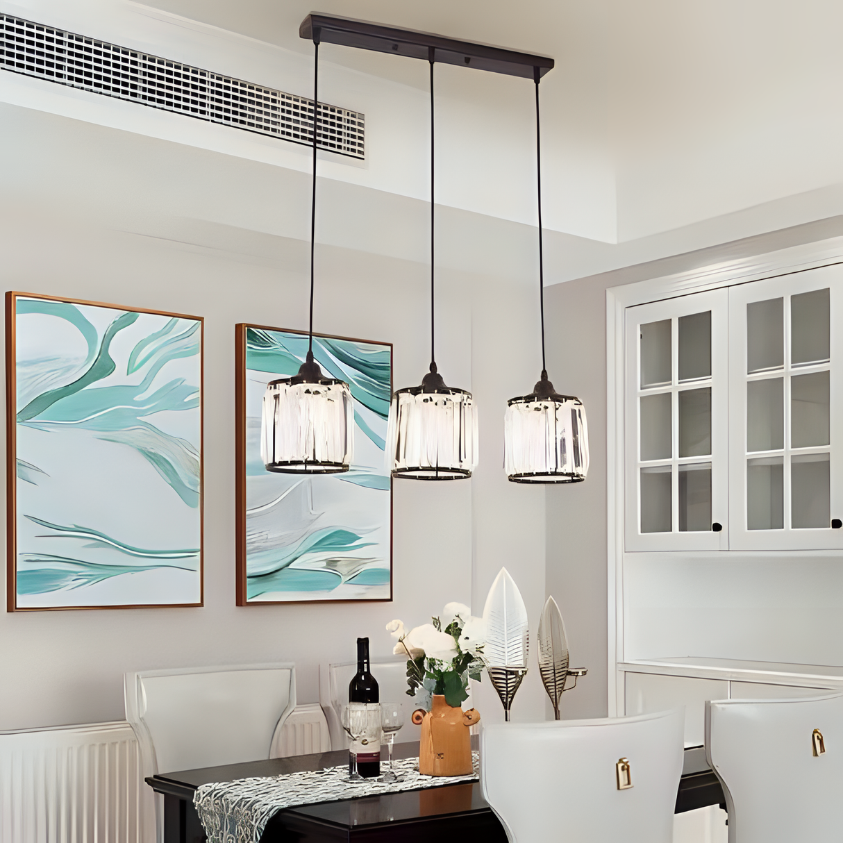 A set of three glass pendant lights with black frames and gold accents hanging over a dining table.