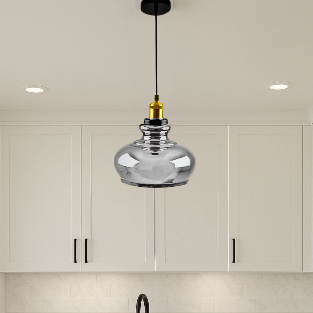 Silver pendant light hanging in a kitchen with white cabinets.