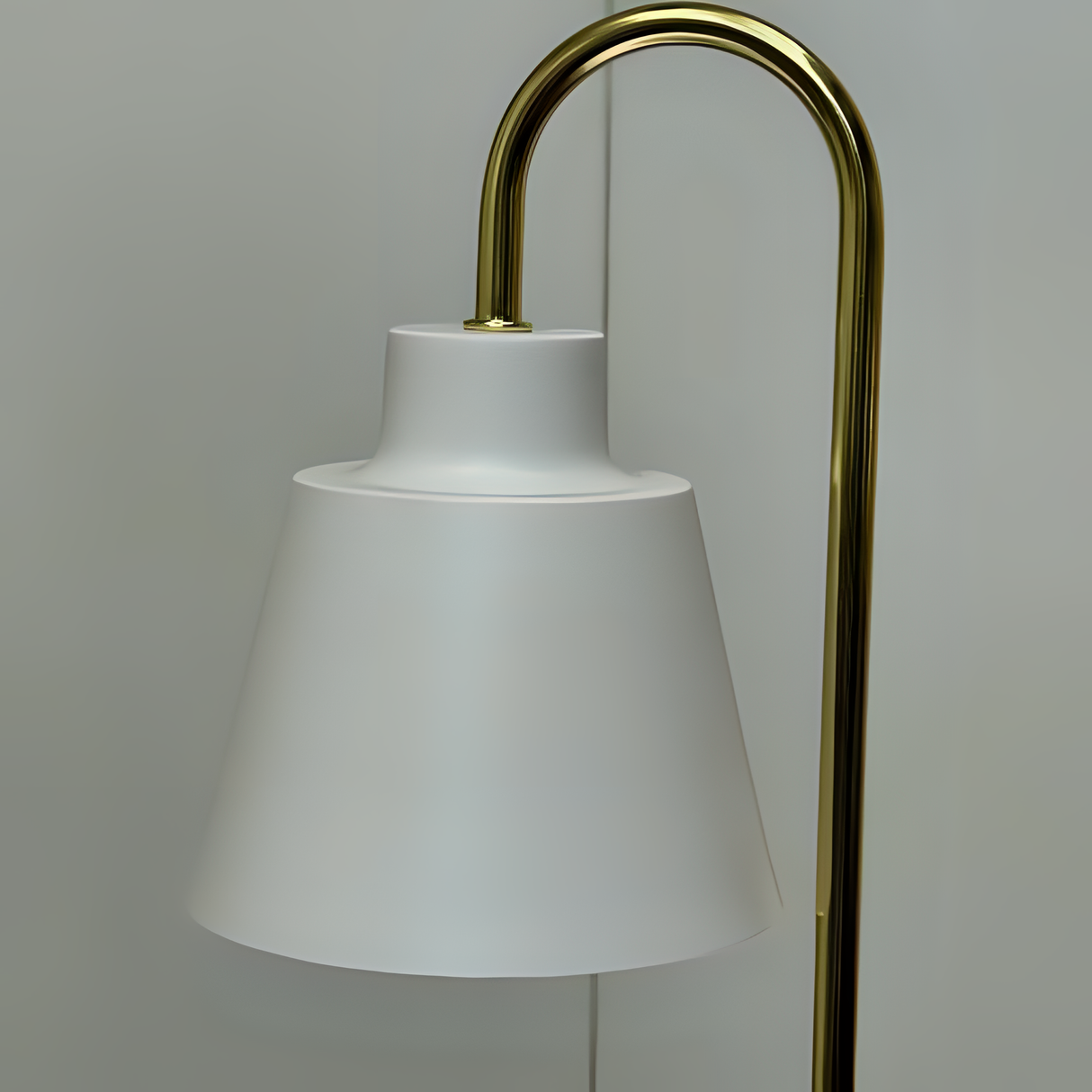a white lampshade resting on a slender gold stand.