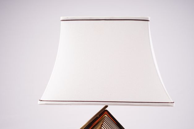 white fabric lampshade with a slightly curved design, accented by two brown lines along the top and bottom edges, adding elegance to the overall look.