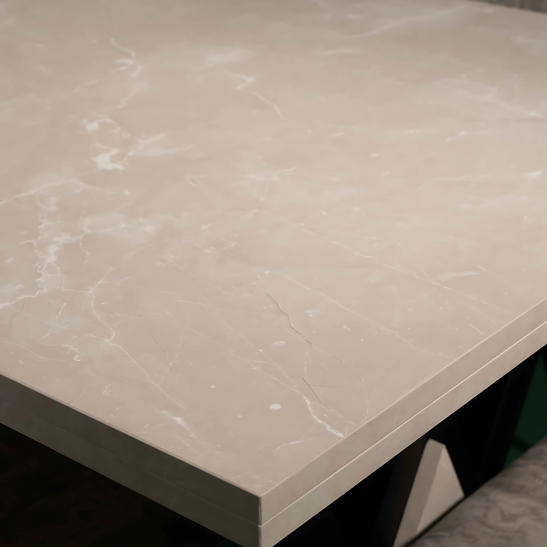 A close-up view of a beige wood tabletop with subtle white veining and a polished finish. The table is supported by a black metal base with a geometric design, partially visible in the lower right corner.