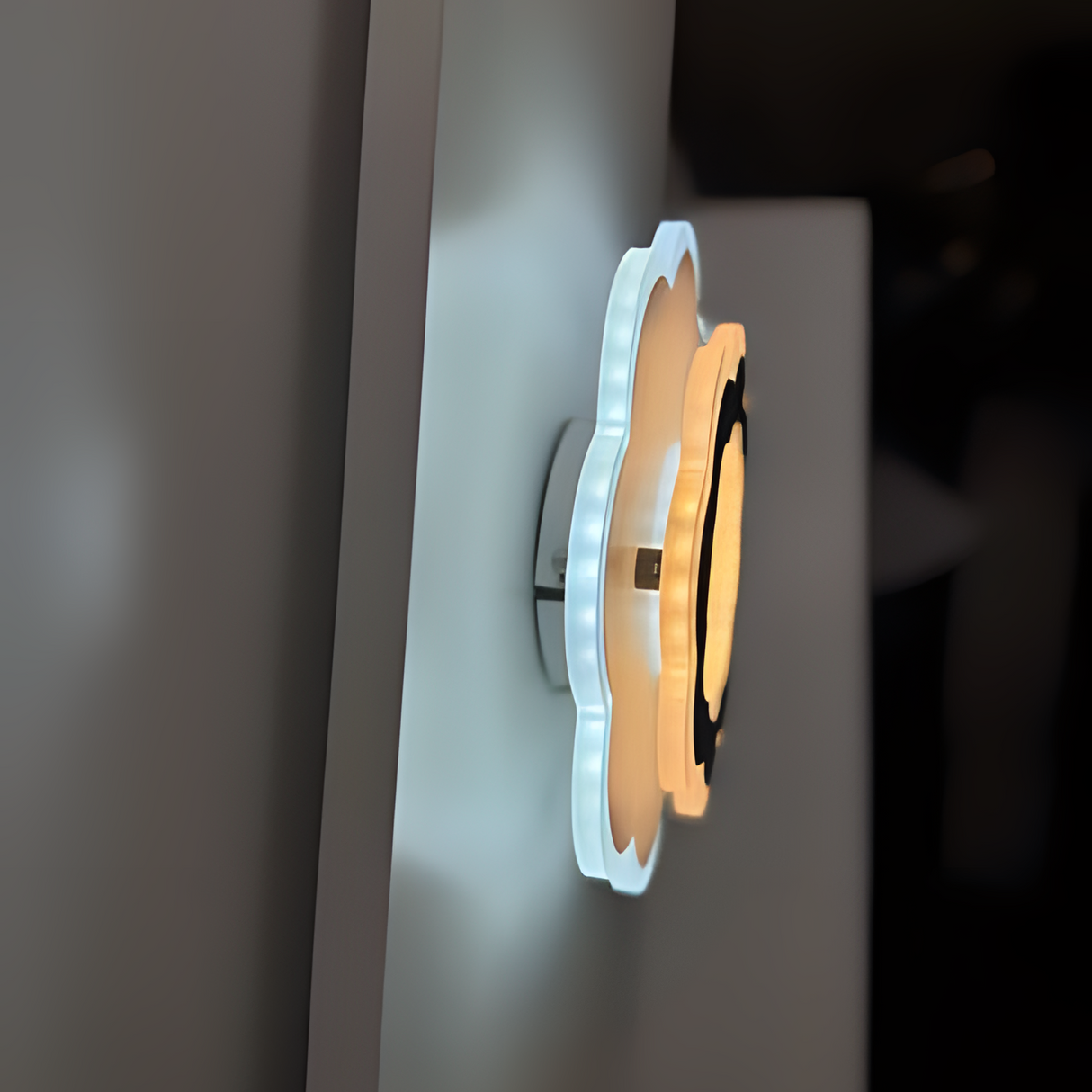Modern Flower LED Wall Light in a sleek flower shape, crafted from metal and acrylic, fixed on a white wall, emitting soft, warm white light.