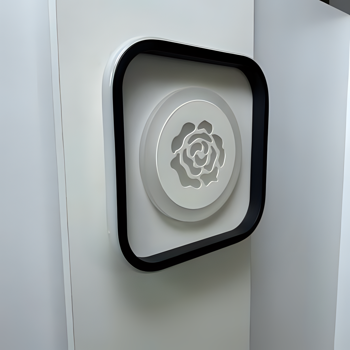 odern square LED wall light with rose-shaped design, fixed on a white wall.