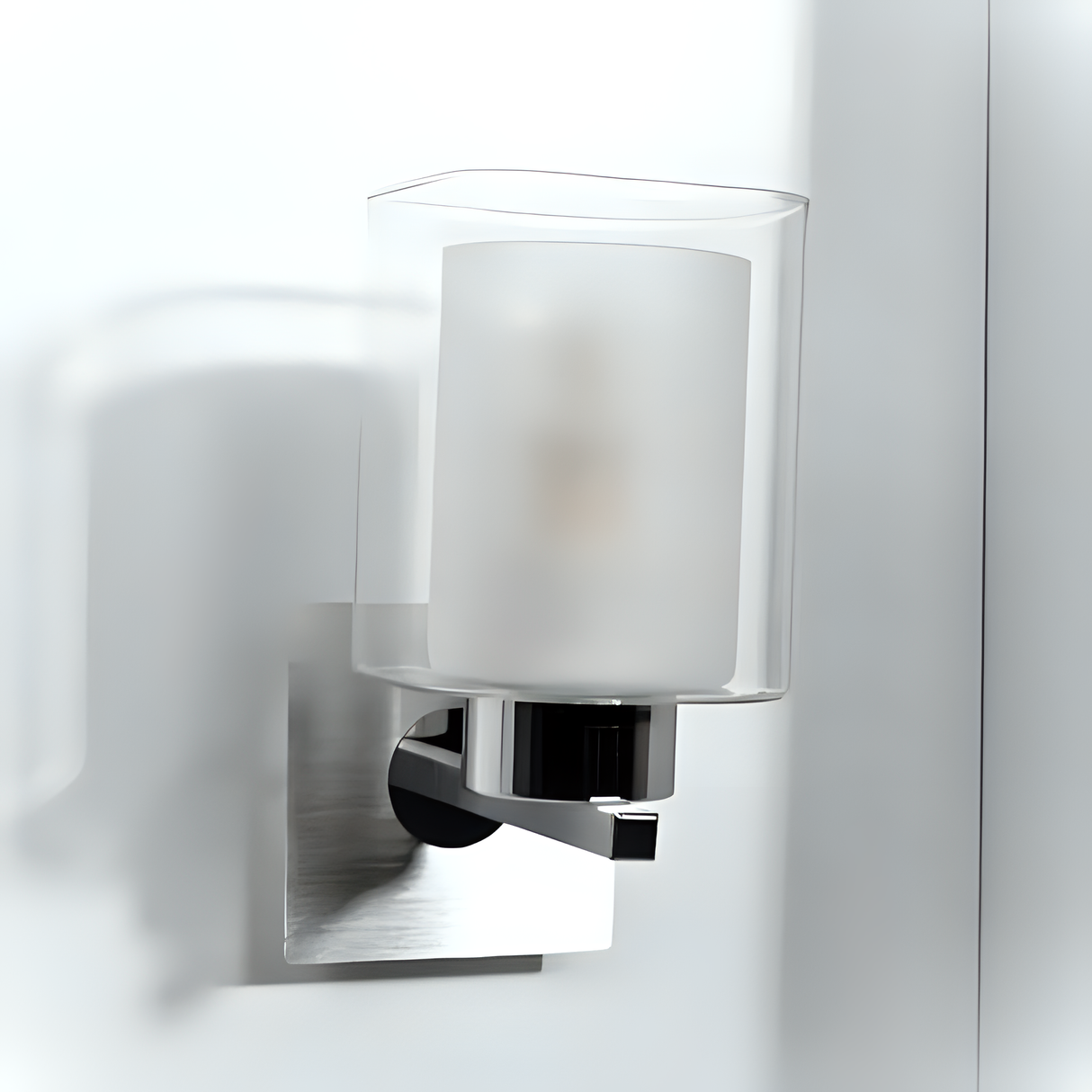 Modern cylindrical wall light with a frosted inner glass shade and clear outer casing, mounted on a brushed metal base.