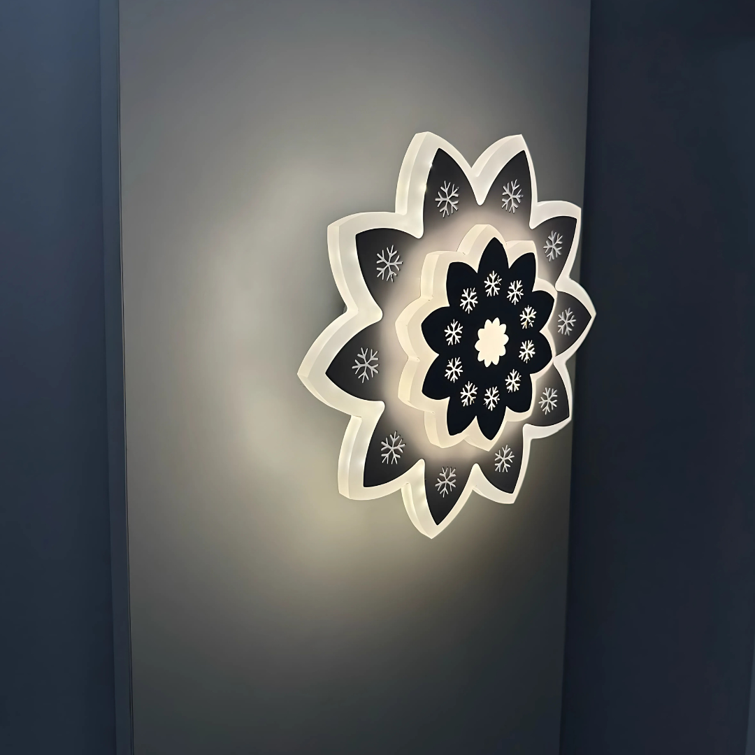 Modern Flower LED Wall Light in a sleek flower shape, crafted from metal and acrylic, fixed on a white wall, emitting soft, warm white light.