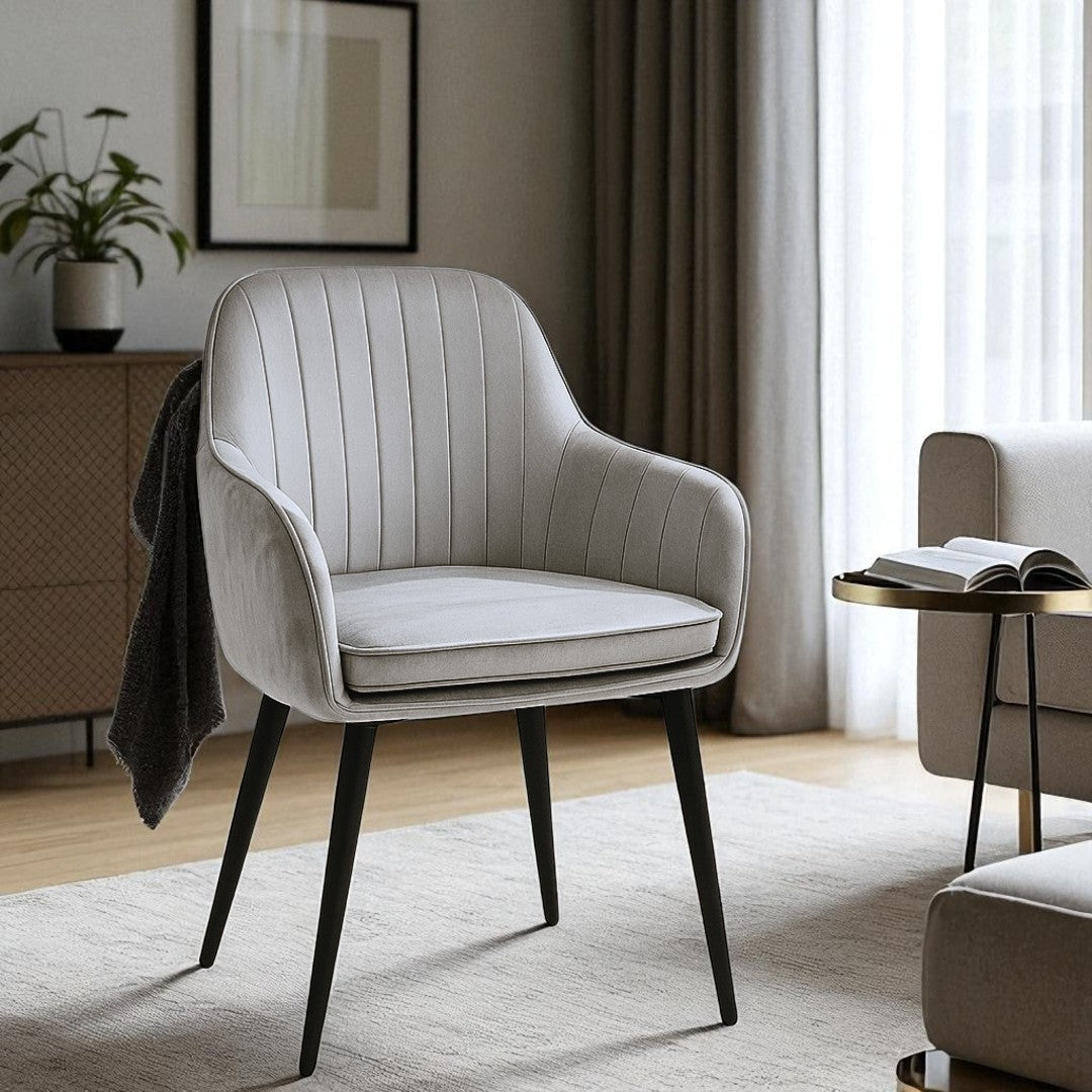 Gray armchair in a modern living room setting with a side table and decor.