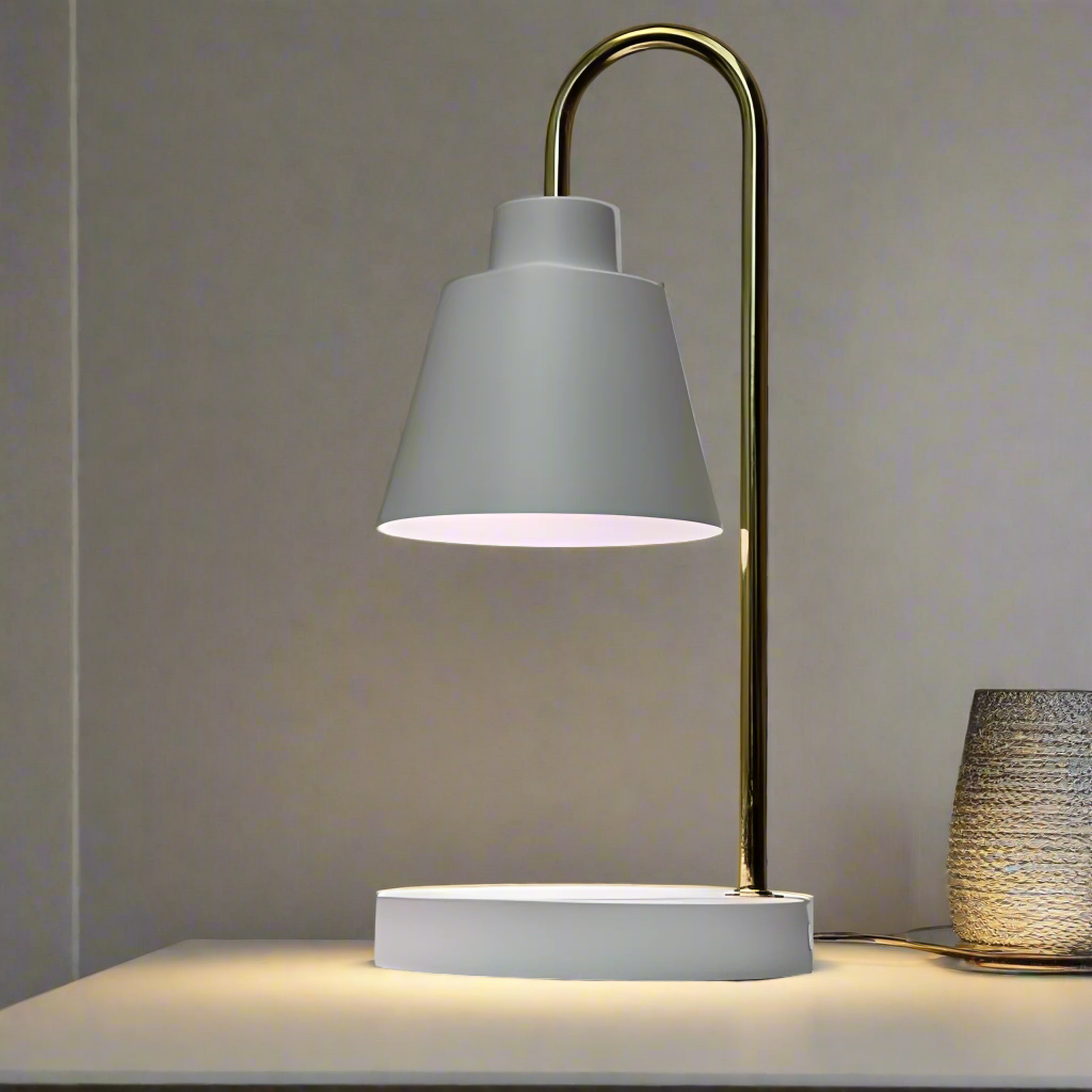 The desk lamp features a sleek and minimalist design with a white lampshade resting on a slender gold stand. The stand curves from a circular white base.