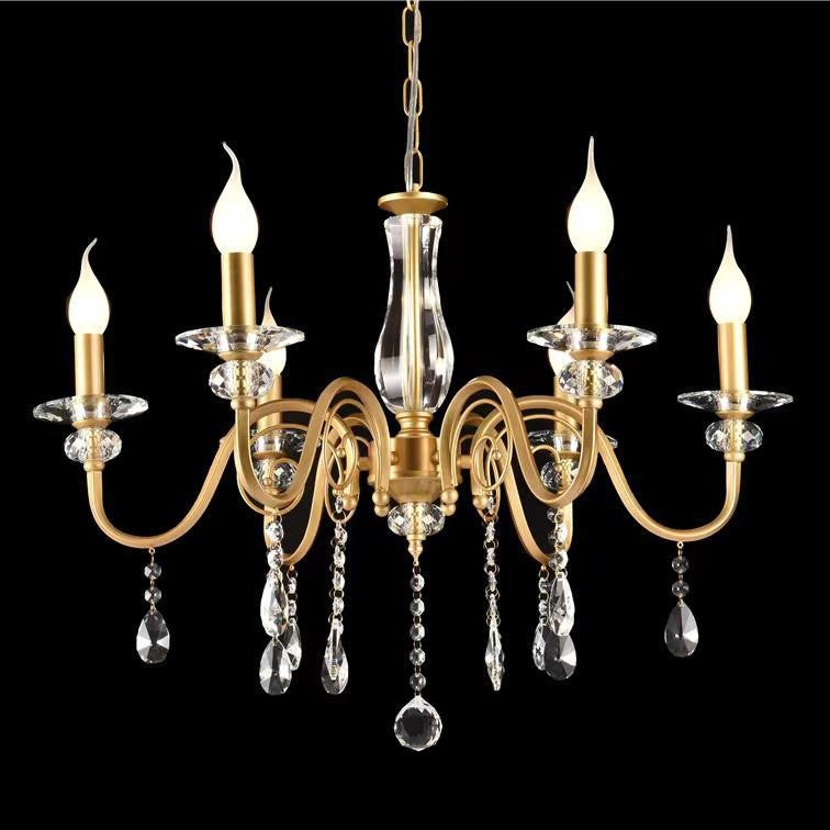 A gold chandelier with curved arms, crystal accents, and candle-shaped bulbs, set against a black background.