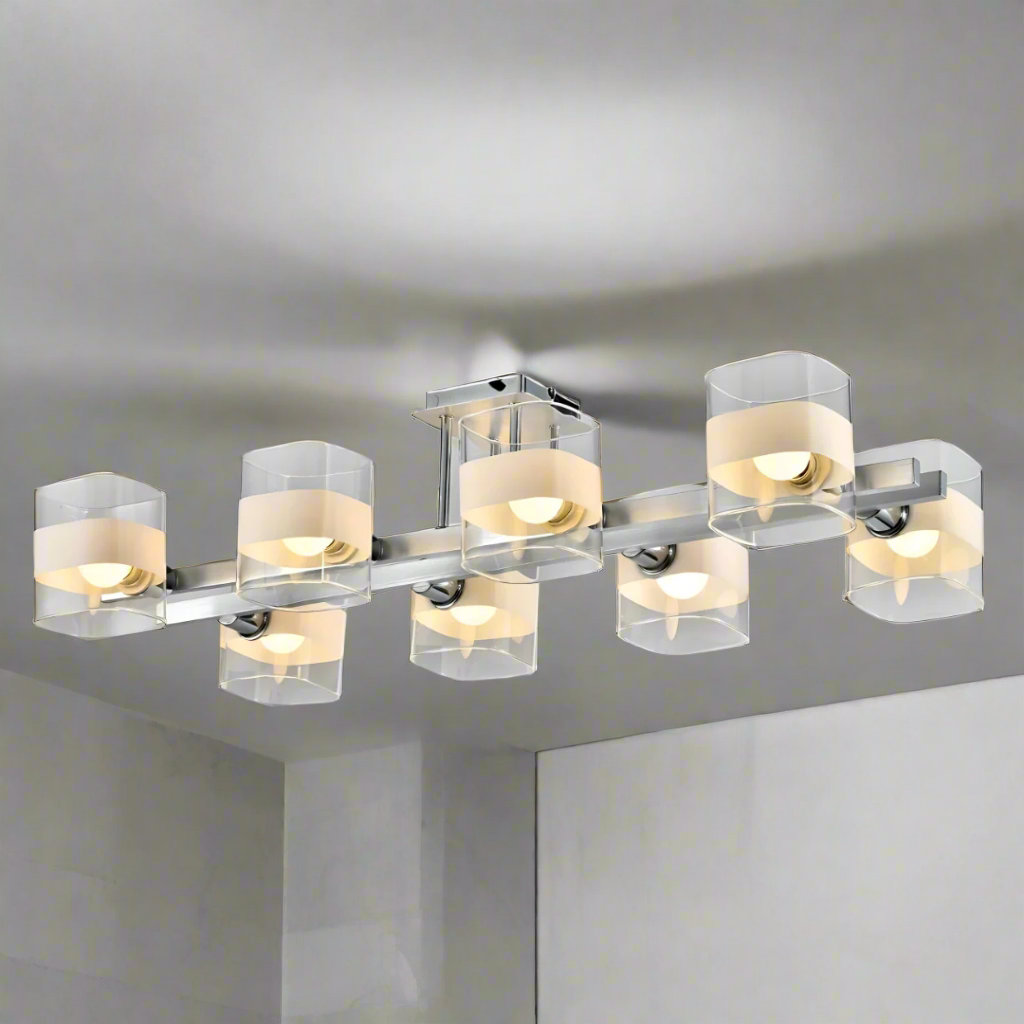 Industrial-style chandelier in brushed metal, with multiple clear and frosted cylindrical glass shades, partially installed with exposed wiring.