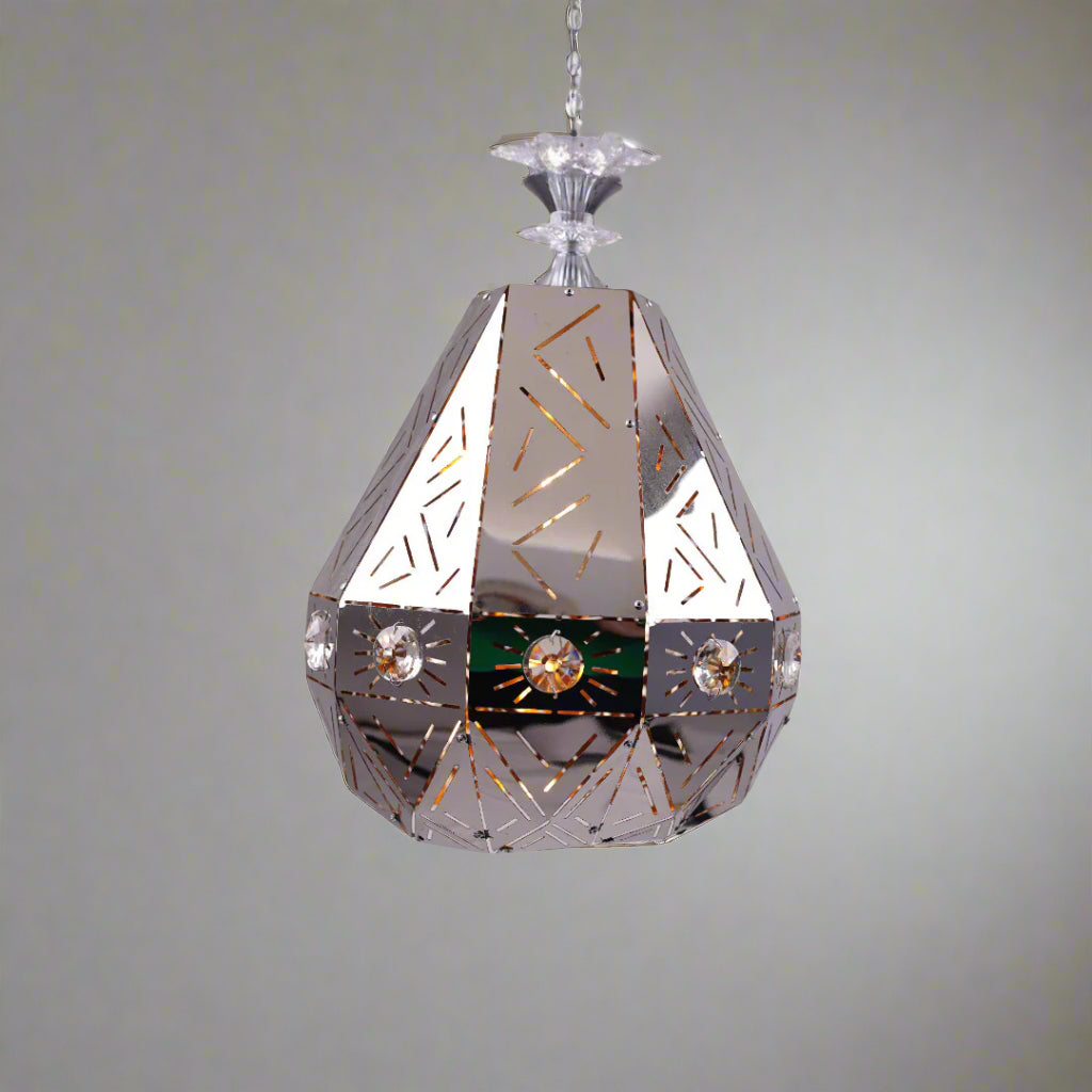 A geometric, faceted metal pendant light with reflective surfaces and decorative patterns, displayed against a soft background.