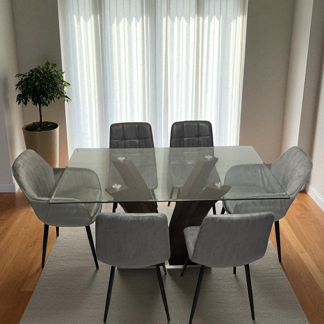 Dining room with a glass table and gray chairs in front of large windows.