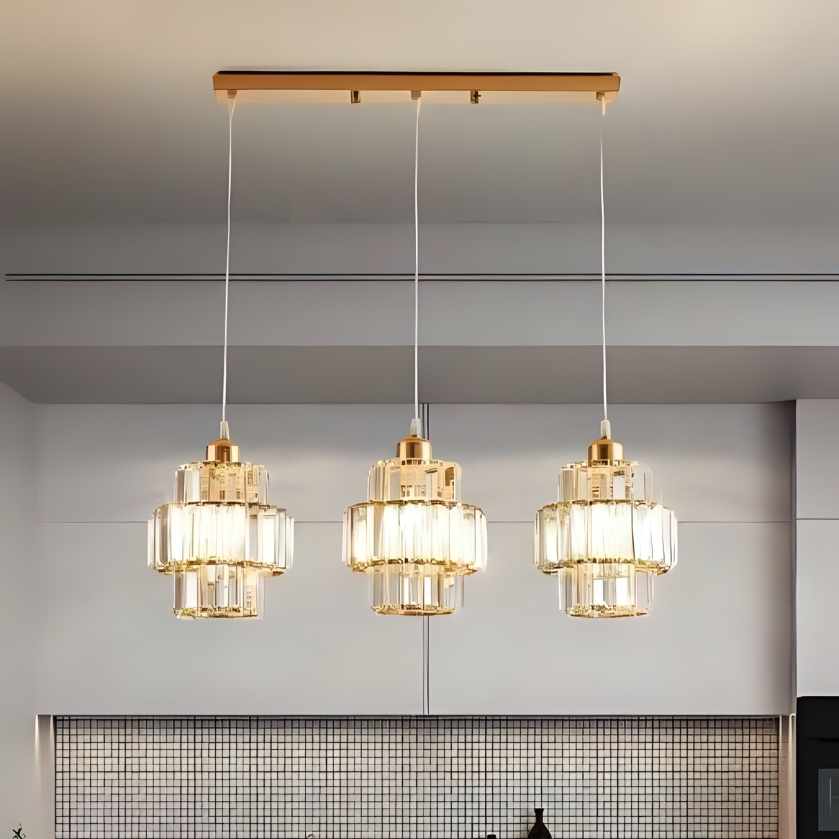 A three-light chandelier with glass and gold elements, suspended from a wooden ceiling mount in a modern interior.