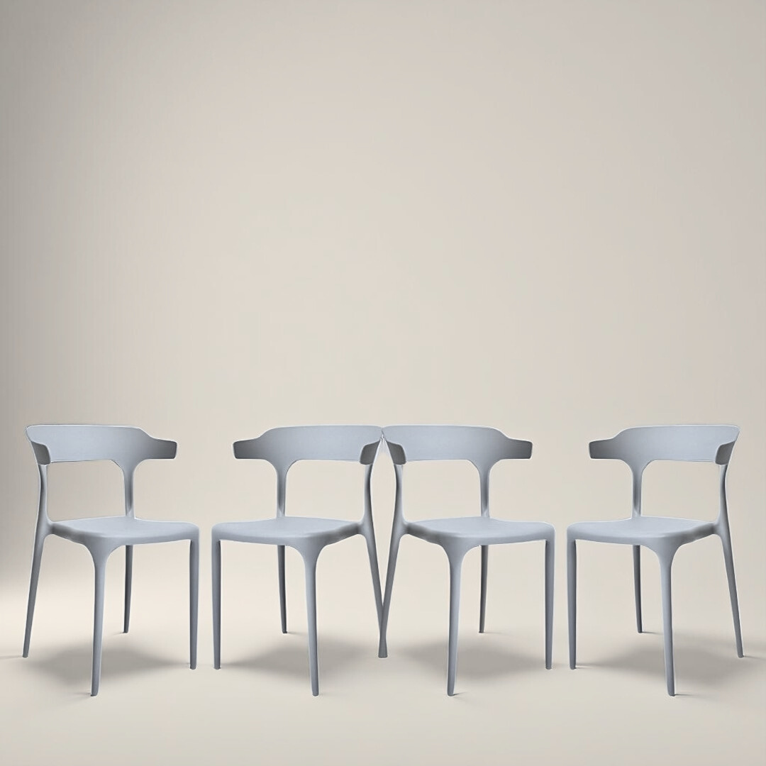 Four grey sculptural chairs with curved backrests and legs, set in a square layout on a neutral background.