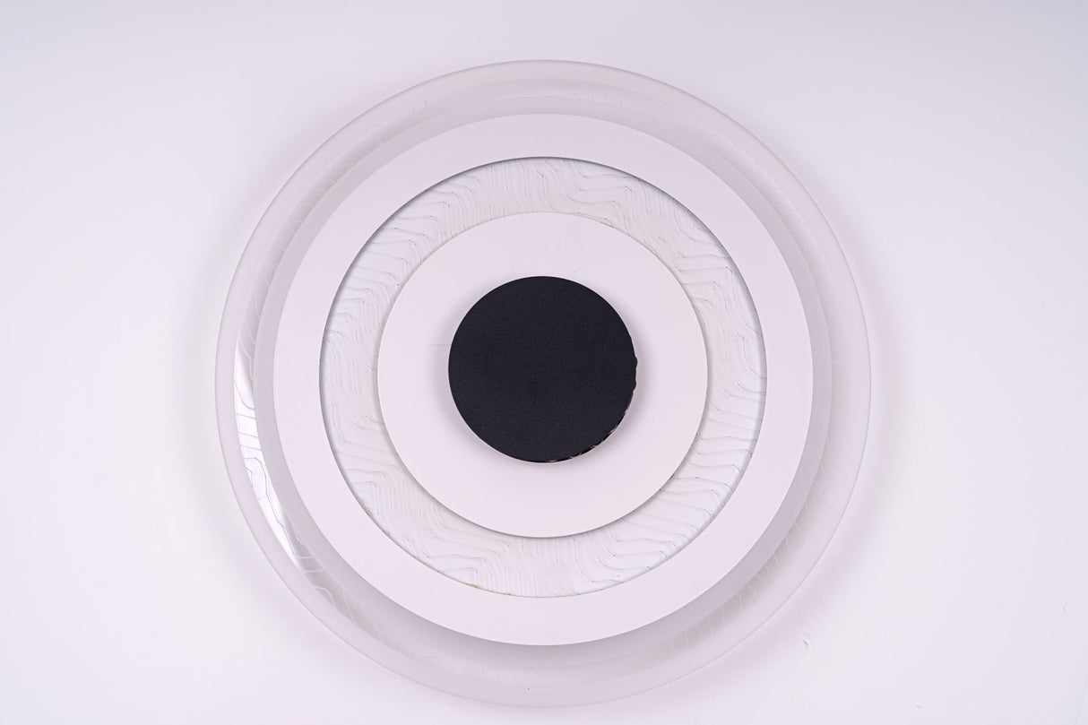 Circular flush mount ceiling light with a layered design of three concentric white rings surrounding a black center, emitting soft white light.