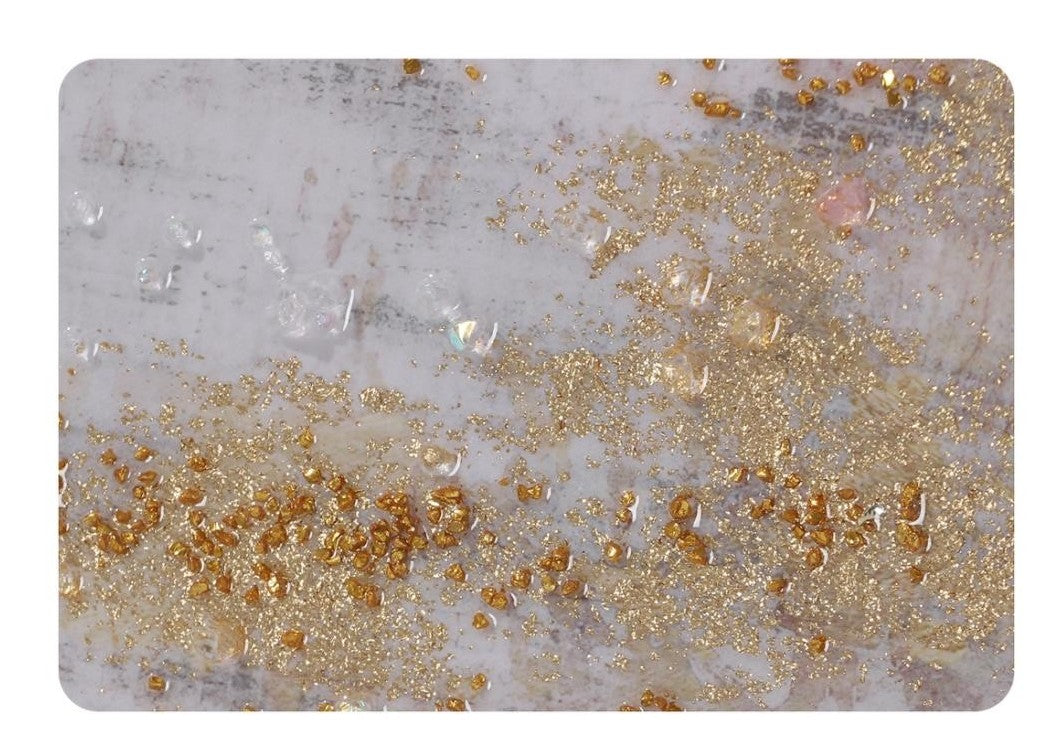 Decorative mat with gold glitter on a textured gray Panel