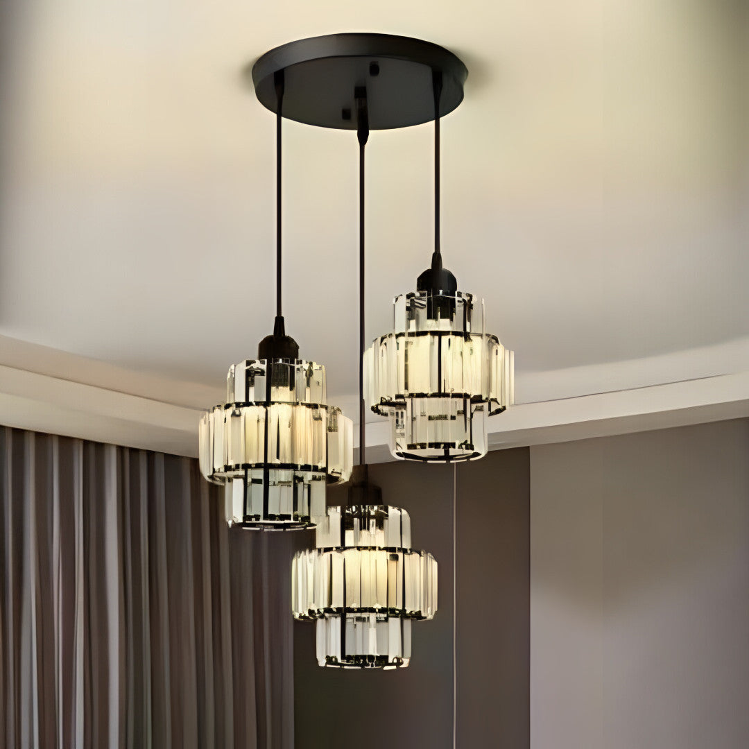A modern chandelier with three black metal and glass pendant lights hanging from a black circular ceiling mount.