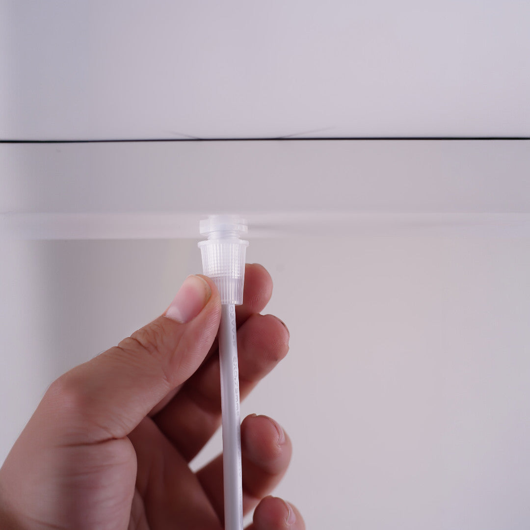 A close-up of a hand adjusting or installing the pendant light cable, showcasing the attachment mechanism.