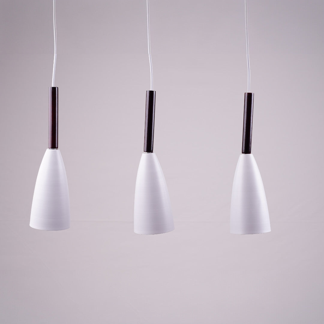 A close-up of the three white pendant lights, highlighting their elegant curved shape.