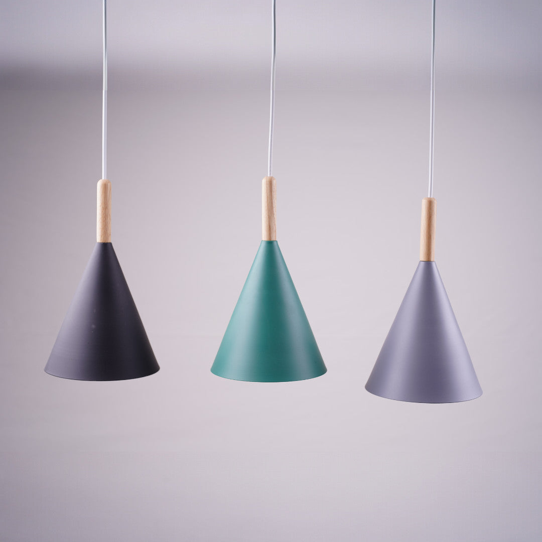 A close-up of three cone-shaped pendant lamps in black, green, and gray, with wooden accents at the top.