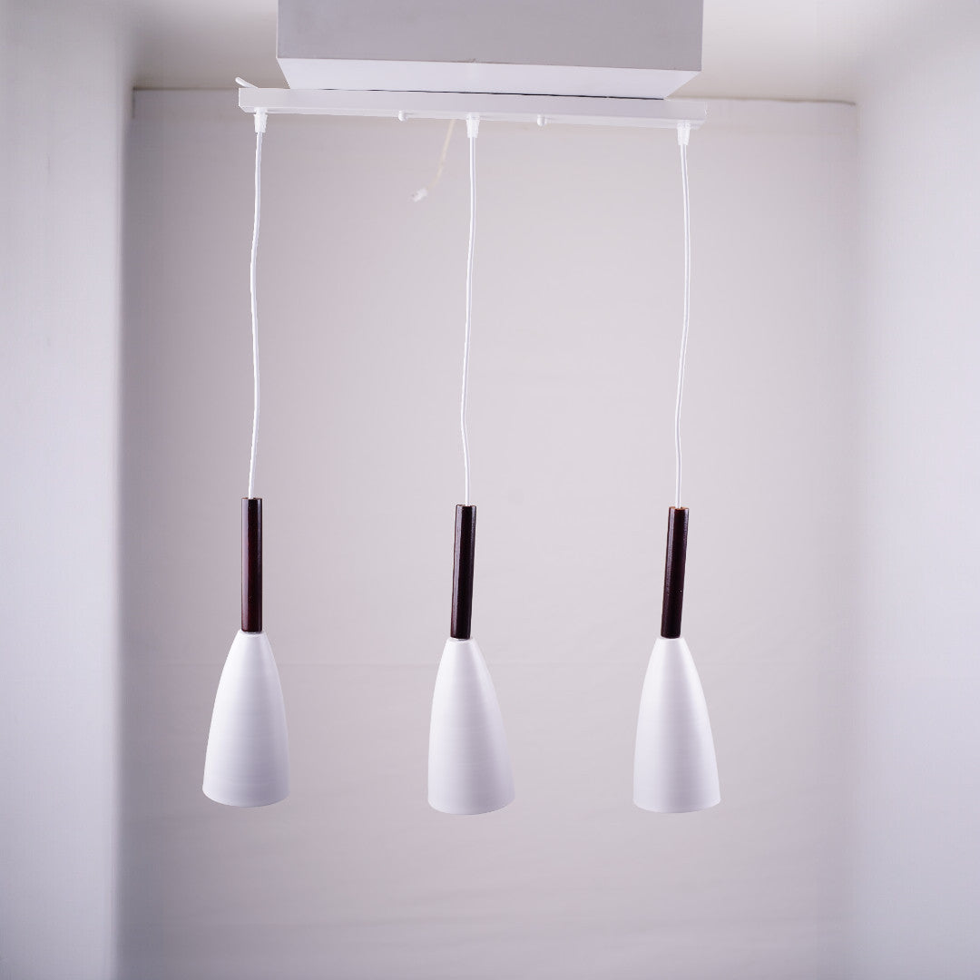 Three sleek pendant lights with white shades and dark metal stems, hanging from a white ceiling mount.