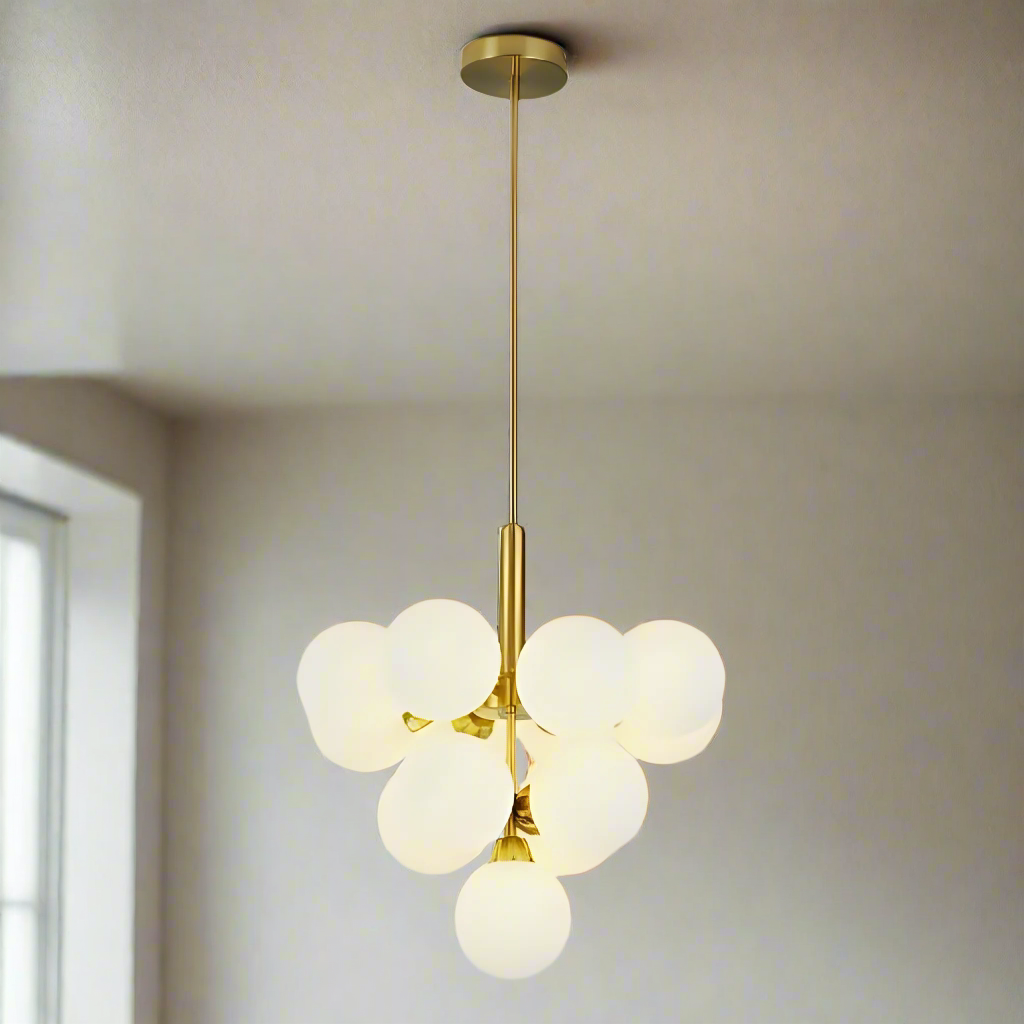 A modern chandelier with white frosted glass globes arranged symmetrically around a gold metal rod, suspended from the ceiling.