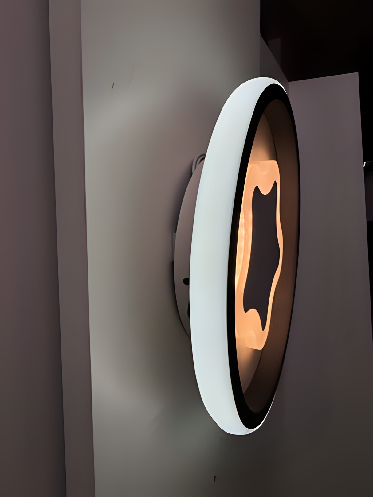 Modern LED Wall & Ceiling Light. Fixed on a white wall, its sleek, wavy design emits a warm, ambient glow, blending style and function effortlessly.