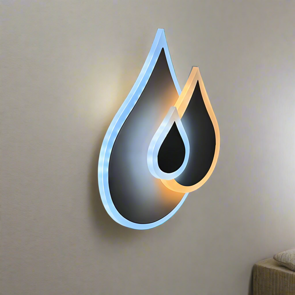 Wall-mounted LED light fixture shaped like two overlapping water droplets, with a soft white and warm white glow illuminating the surrounding wall.
