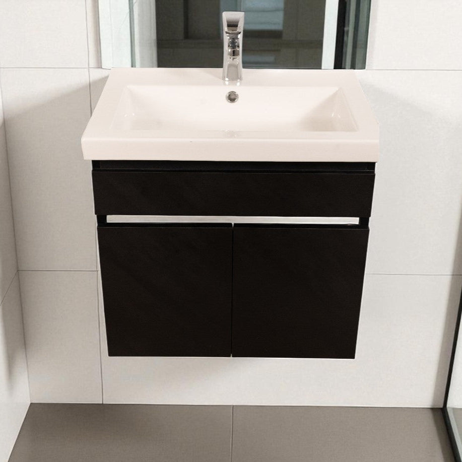 Bathroom vanity with black cabinet and white countertop against a tiled wall.