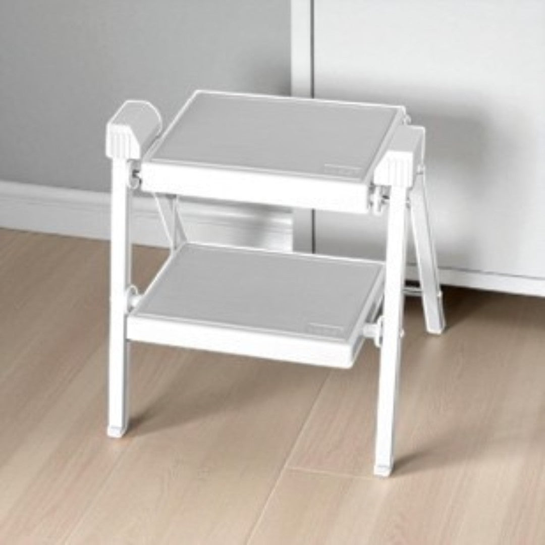 White step stool on a wooden floor.