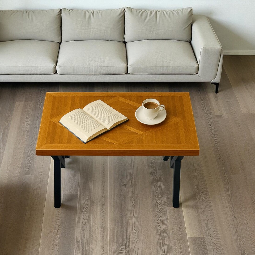 Wooden coffee table with an open book and a cup on a light wood floor.