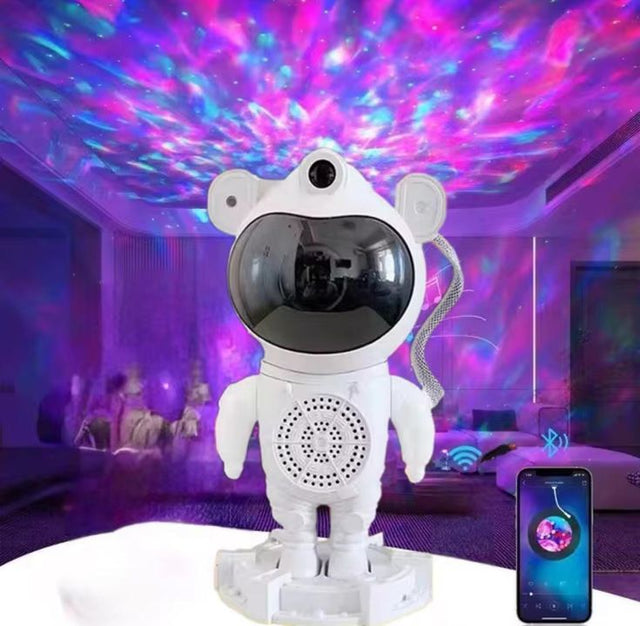 Astronaut-shaped robot with LED lights projecting a colorful sky pattern on a ceiling.