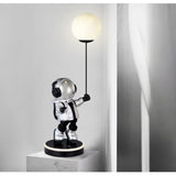 Astronaut lamp holding a light bulb on a gray background