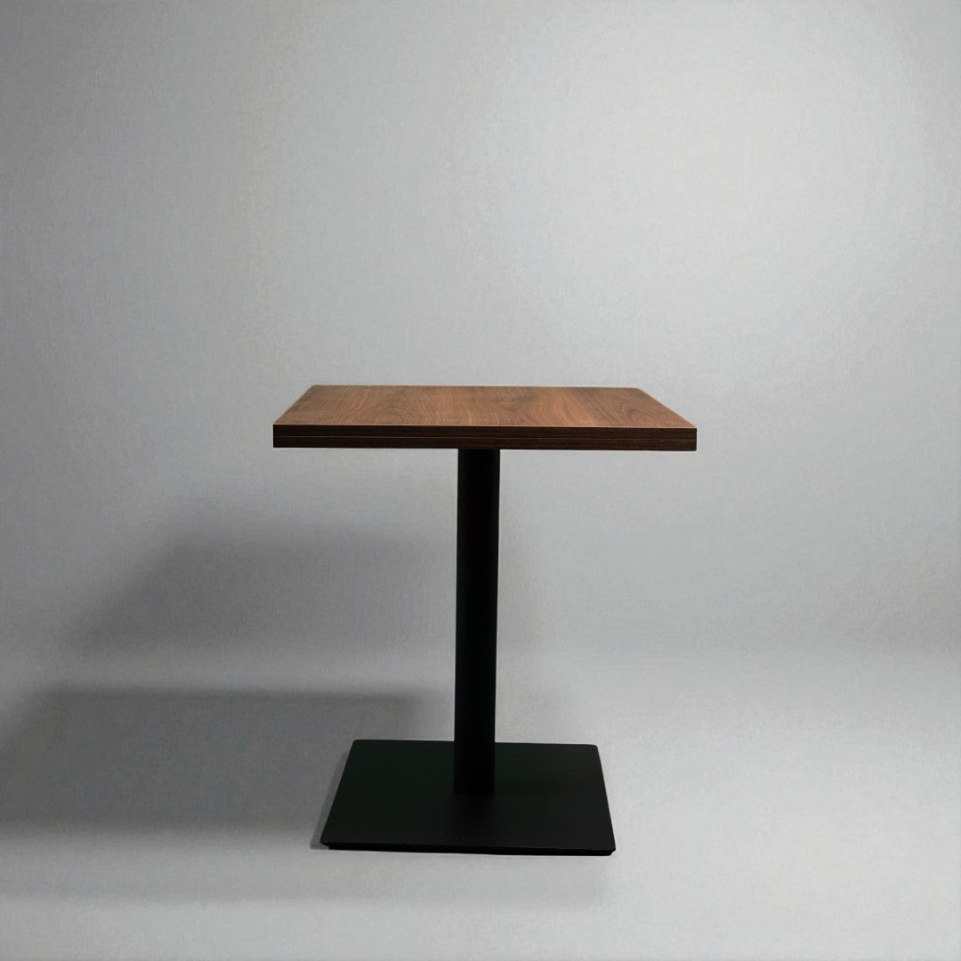 Small wooden table with a black metal base on a gray background