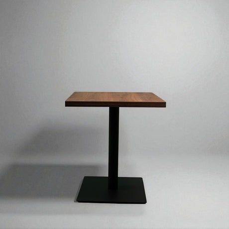 Small wooden table with a black metal base on a gray background
