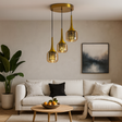 Modern living room with a beige sofa, decorative pillows, a coffee table with fruit bowl, and pendant lights.