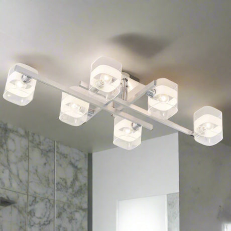  Industrial-style chandelier in brushed metal, with multiple clear and frosted cylindrical glass shades, partially installed with exposed wiring.