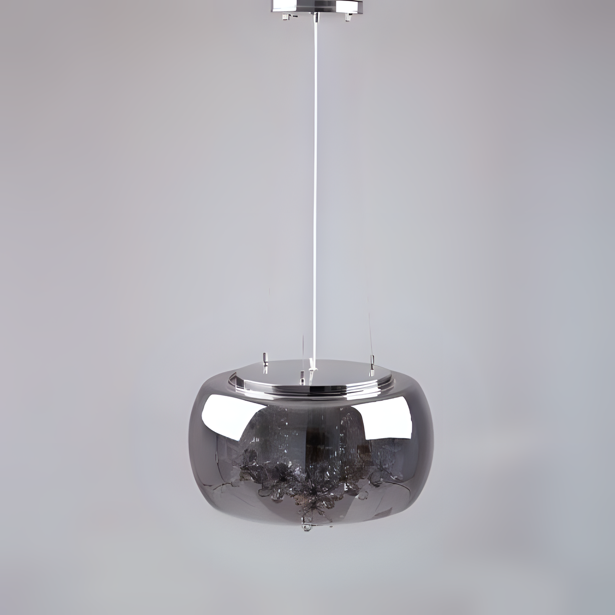 A sleek and minimalist metallic pendant light with a reflective chrome dome-shaped shade, suspended by a thin white cord against a plain light grey background.