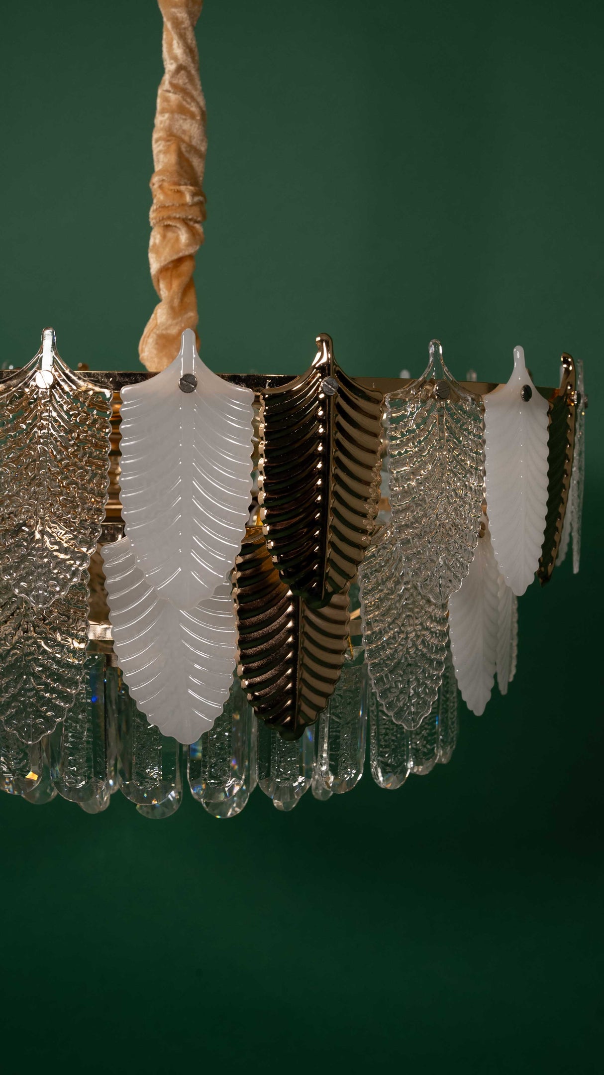 A side angle of the chandelier, showing its symmetrical arrangement of glass leaves, suspended by a twisted golden chain for an elegant look.