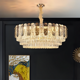  A close-up view of an elegant crystal chandelier with a circular design, mounted on a dark ceiling, with a modern painting in the background.