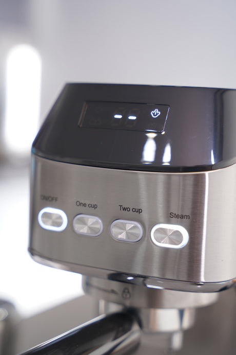 Close-up of a coffee machine with control buttons on a blurred background